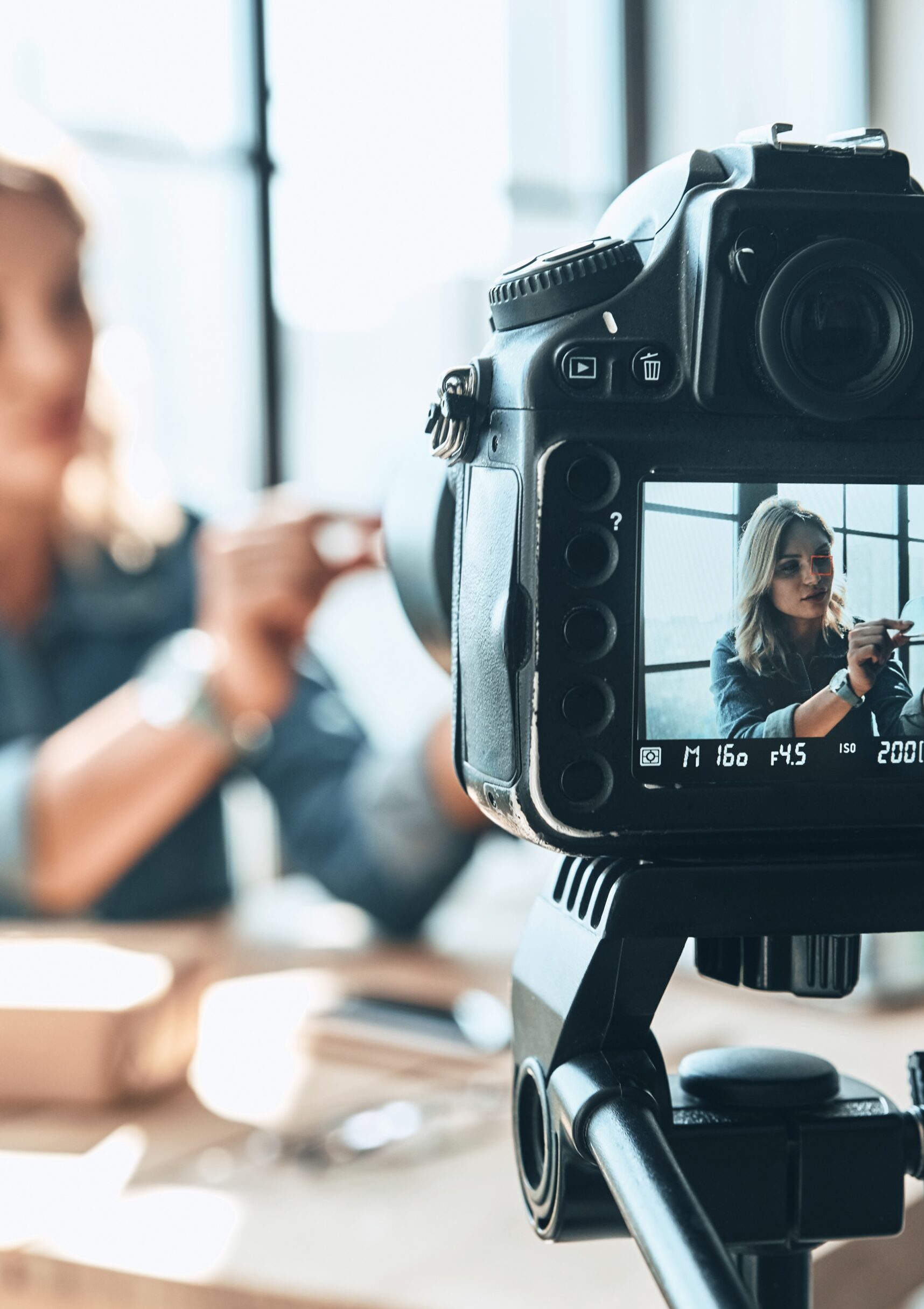 Her new video is awesome. Beautiful young woman in casual wear recording video while sitting indoors